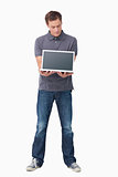 Young man showing screen of his laptop
