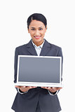 Close up of smiling saleswoman presenting screen of laptop