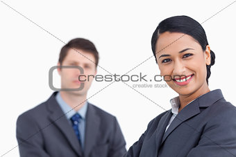 Close up of smiling saleswoman with co-worker behind her