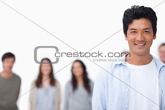 Smiling young man with friends standing behind him