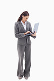 Businesswoman standing and typing on a laptop