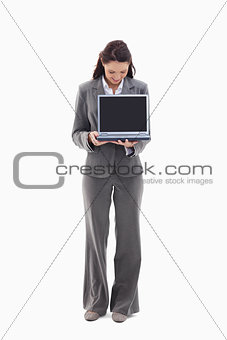 Businesswoman looking and showing a laptop screen