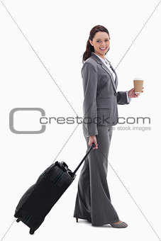 Profile of a businesswoman smiling with a suitcase and holding a