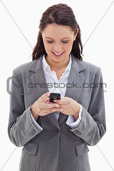 Businesswoman smiling and watching her phone