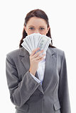  Businesswoman hiding behind a lot of dollar bank notes