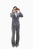 Businesswoman smiling and looking through binoculars