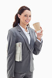 Businesswoman smiling with a newspaper drinking a coffee