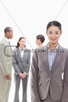 Businesswoman smiling with co-workers in the background