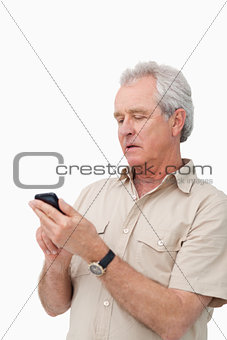 Mature man typing text message on his cellphone