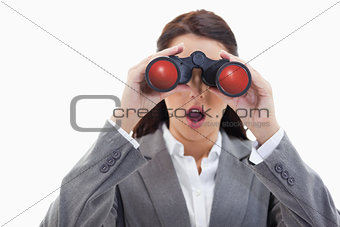 Close-up of a surprised businesswoman looking through binoculars