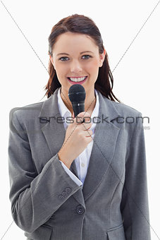 Businesswoman smiling and holding a microphone