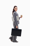 Profile of a businesswoman smiling and walking with a briefcase,