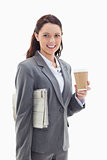 Businesswoman smiling with a newspaper and a coffee