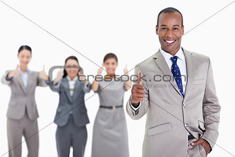 Happy businessman with a hand in his pocket approving with co-wo