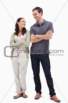 Couple with a complicit smile while crossing their arms