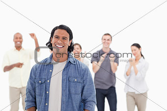 Close-up of a man laughing with people applauding