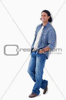 Man laughing while leaning against a wall
