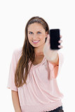 Close-up of a smiling girl showing a smartphone 