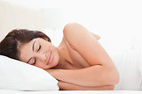 Woman lying in bed, head on pillow, sleeping, 