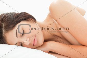 A woman sleping on the bed, with her head resting on the pillow 