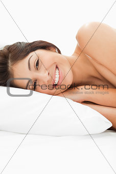 A woman lying on the bed, her head on the pillow, her eyes are o
