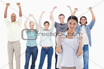 Close-up of a woman clenching her fists with people raising thei