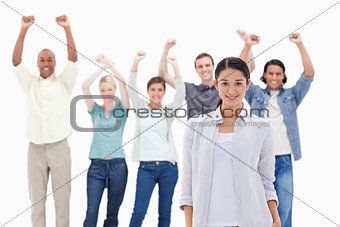 Close-up of a girl with people raising their arms 