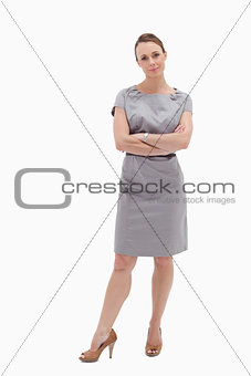 Woman in dress standing with her arms folded