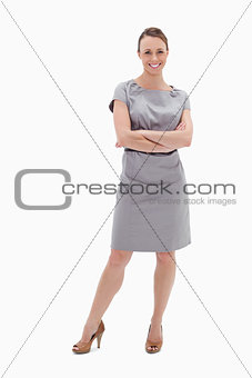 Smiling woman in dress with her arms folded