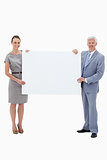 White hair businessman smiling and holding a big white sign with