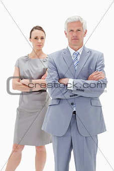 Serious white hair businessman with a woman behind him crossing 