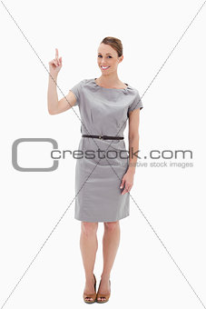 Woman posing in a dress showing something above with her hand