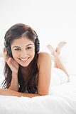 Close up, woman with a hand on her headphones and her legs cross