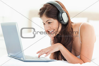 Smiling woman using the mouse pad to scroll on a laptop while we