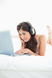 Woman listening to her headphones and watching her laptop, with 