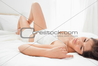 Woman resting on her back with her knee raised up and her hand b