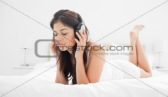 Woman holding her headphones while listening to music with her e