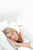 Vertical shot, woman sleeping in bed, with hands and head restin