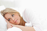 Woman resting in bed, eyes open and glancing just ahead of her