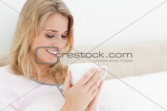 Close shot, Woman looking into the cup in her hands and smiling
