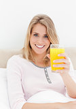Close up, Woman looking forward smiling while holding up a glass