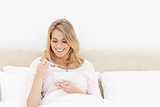 Woman looking at a spoon of cereal while sitting in bed
