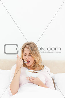 Vertical shot, Woman about to eat a spoon of cereal with her mou