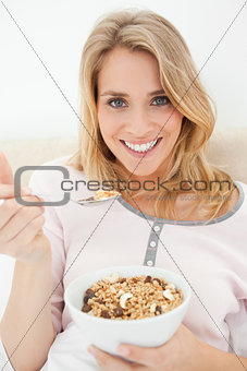 Close up, Woman smiling and looking forward with a raised spoon 