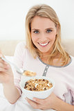 Close up, woman smiling as she is offering a spoon of cereal