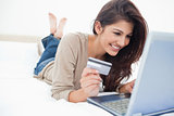 Woman on her laptop with credit card in hand and smiling