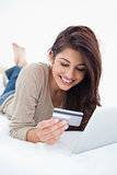 Close up, woman reading credit card infront of tablet