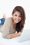 Woman smiling infront of her tablet, as she looks in front of he