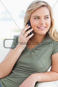 Close up, woman making a call while looking to the side and smil