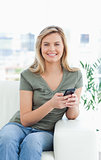 Close up, woman smiling as she uses her phone, while looking for